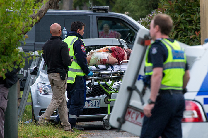 Frankston Siege: The person of interest is wheeled out on a stretcher. Picture: Gary Sissons