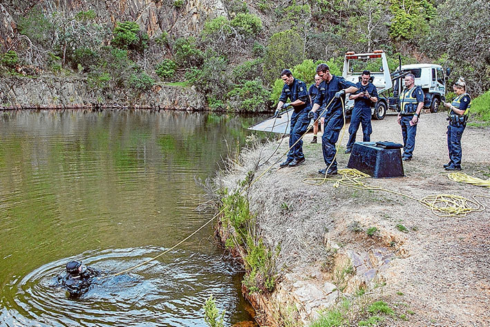 Making a splash: Police search for a car reported by early morning walkers who saw it sink in Moorooduc quarry soon after it was driven through a gate from Station St, Mt Eliza. Picture: Gary Sissons