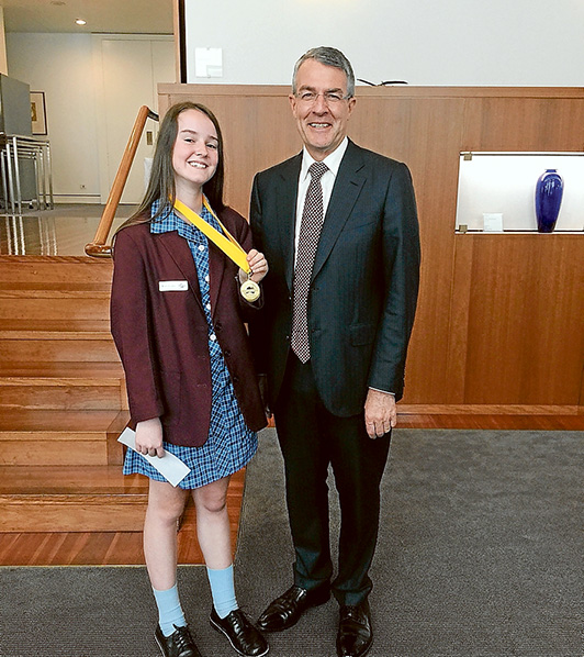 All in the family: Madison Lalor proudly shows off her medallion to Federal Liberal Isaacs MP Mark Dreyfus. Picture: Gary Sissons