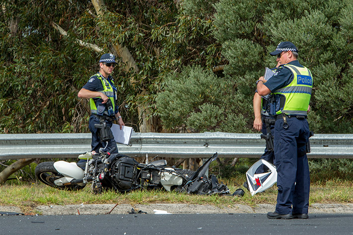 Police look at the wreck of the Motorcycle. Photo: Gary Sissons.