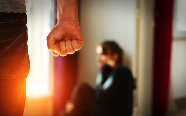A man's fist threatening a woman