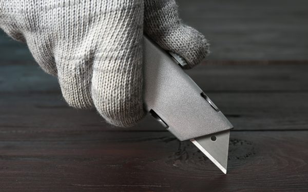 Image of a man holding a box cutter